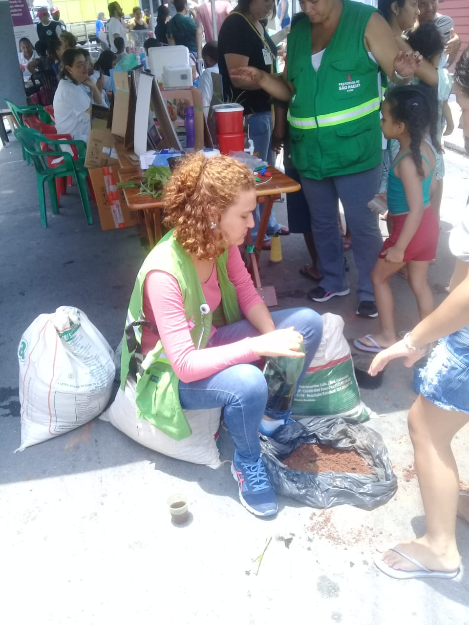 foto de uma mulher com um saco de terra